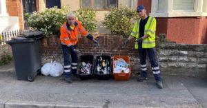 Rubbish collectors by boxes of recycling