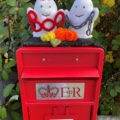 terrifying knitted ghosts on top of a postbox